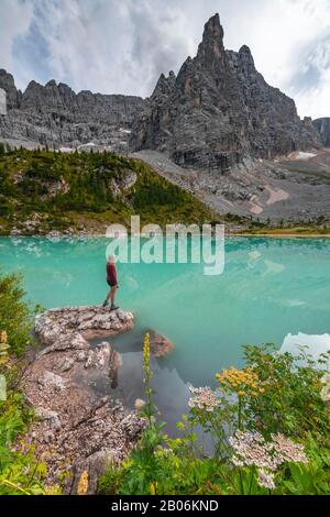 Junge Frau, Wanderer am türkisgrünen Sorapis-See, Lago di Sorapis, Berggipfel Dito di Dio, in den Dolmen, Belluno, Italien Stockfoto