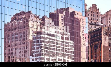 New Yorker Altbauten spiegelten sich in Fenstern eines modernen Wolkenkratzers wider, farbiger urbaner Hintergrund. Stockfoto