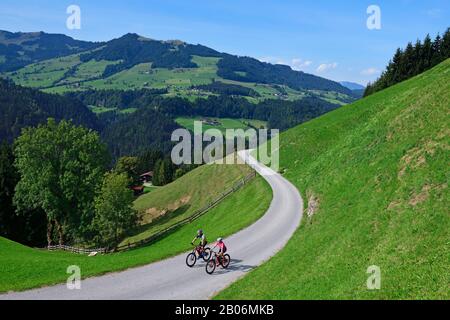 Zwei Radfahrer mit Elektro-Mountainbikes auf dem Glantersberg mit Blick auf die hohe Salve, Kitzbüheler Alpen, Tyrol, Österreich Stockfoto