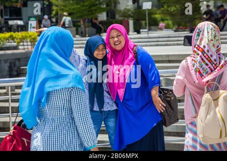 muslimische Mutter und Tochter aus Indonesien lächeln und posieren für ein unvergessliches Bild während ihrer Reise nach Singapur. Stockfoto