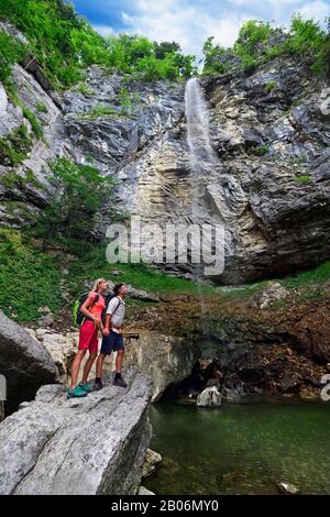 Wanderer vor dem Wasserfall Schossrinn, Sachrang, Chiemgau, Oberbayern, Bayern, Deutschland Stockfoto