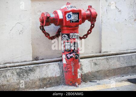 Roter Außenhydrant mit Aufklebern Stockfoto