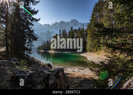 Blick auf die Berge vom Ufer des Eibsee an einem sonnigen Nachmittag. Stockfoto