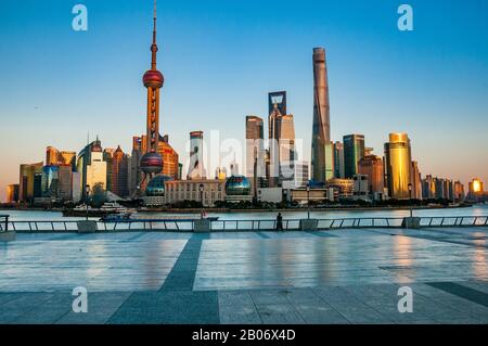 Zwei einsame Touristen tapferen dem Coronavirus auf Shanghai normalerweise lebhaften Bund mit der Pudong Skyline dahinter. Stockfoto