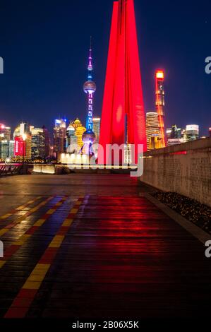 Denkmal für die Volkshelden mit der Skyline von Pudong hinter der blauen Stunde am frühen Abend in Shanghai, China. Stockfoto