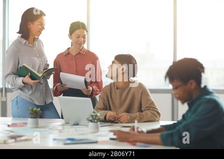 Gruppe junger Geschäftsleute, die während eines Meetings im Büro im Team arbeiten Stockfoto