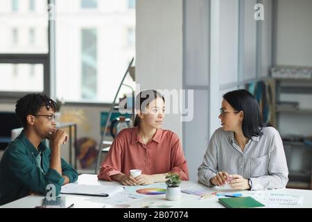 Multiethnische Gruppe junger Geschäftsleute, die gemeinsam während der Geschäftstreffen im Büro über einen neuen Plan nachdenken Stockfoto