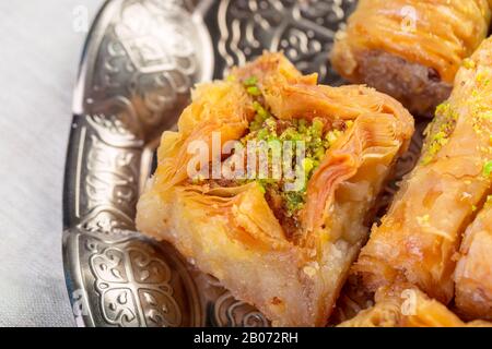 Türkische Süßigkeiten Baklava und Metall-Orientale-Tablett auf Holzhintergrund Stockfoto