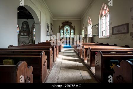 St. Andrew's Parish Church, Wimpole, Cambridgeshire, Großbritannien. Das Innere einer alten ländlichen englischen Kirche mit ihren originalen Holzpfauen und ihrem Altaraufsatz. Stockfoto