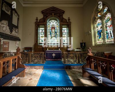 St. Andrew's Parish Church, Wimpole, Cambridgeshire, Großbritannien. Das Innere einer alten ländlichen englischen Kirche mit ihren originalen Holzpfauen und ihrem Altaraufsatz. Stockfoto