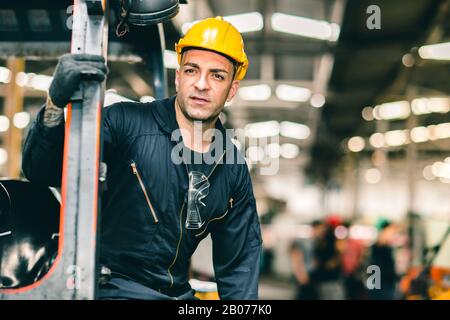 Portrait des kaukasischen Fabrikarbeiters hübsche Smart mit Sicherheitskleidung und gelbem Helm. Stockfoto