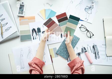 Nahaufnahme der Geschäftsfrau, die farbige Palette hält und eine Farbe an ihrem Arbeitsplatz im Büro wählt Stockfoto
