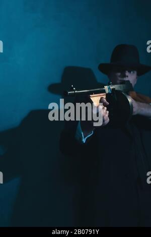 Retro-Gangster in Hutschüssen mit Maschinengewehr. Stockfoto