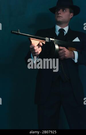 Retro-Gangster in Hutschüssen mit Maschinengewehr. Stockfoto