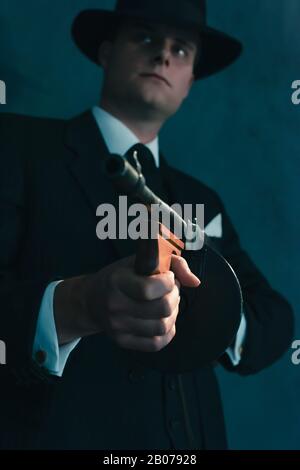 Retro-Gangster in Hutschüssen mit Maschinengewehr. Stockfoto