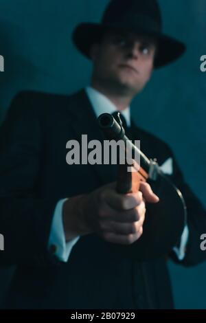 Retro-Gangster in Hutschüssen mit Maschinengewehr. Stockfoto