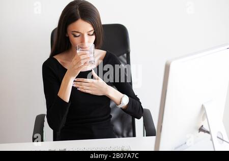 Herzschmerzen. Frau, die Panikattacke am Arbeitsplatz hat Stockfoto