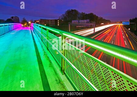 Beleuchtete Regenbogenbrücke über die Motoway A40 im Zwielicht, Deutschland, Nordrhein-Westfalen, Ruhrgebiet, Dortmund Stockfoto