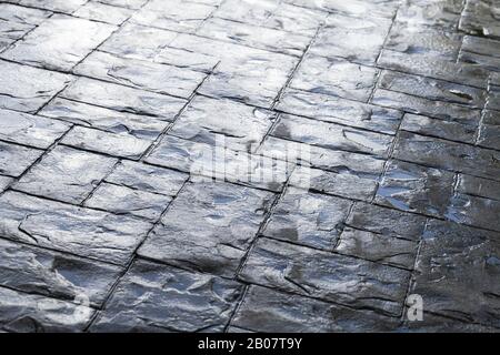 Glänzend nass grau Kopfsteinpflaster Straße, Hintergrund Foto Textur Stockfoto