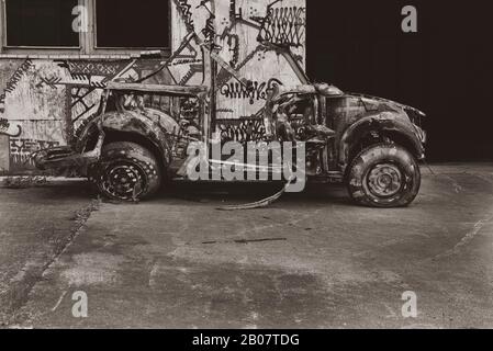 Ein altes, komplett zertrümmtes Auto, Old Car Wreck, flacher Kontrast, Schwarz-Weiß-Foto Stockfoto