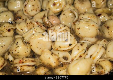 In einer Pfanne mit Gewürzen gekochte Knödel. Nahaufnahme Stockfoto