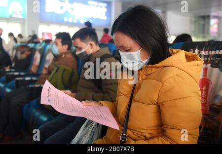 (200219) -- BAISE, 19. Februar 2020 (Xinhua) -- EIN wiederkehrender Arbeiter liest ein Mitteilungsblatt am Baise-Bahnhof in Baise, Südchina Guangxi Zhuang Autonomes Gebiet, 19. Februar 2020. Der personalisierte Zug beförderte etwa 700 zurückkehrende Arbeiter aus Baise von Guangxi nach Guangzhou von Guangdong, um ihre Arbeit wieder aufzunehmen. (Xinhua/Lu Boan) Stockfoto