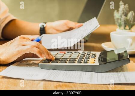 Geschäftsmann analysiert Anlagediagramme mit dem Rechner für Gewinn und Verlust. Stockfoto