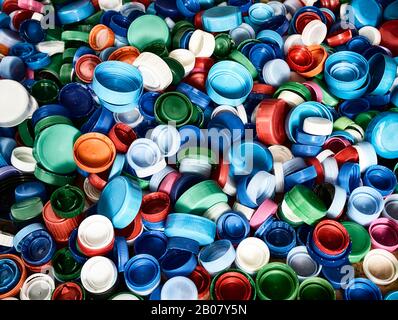 Hochauflösende Draufsicht im Hintergrund in verschiedenen Farben und Größen Kunststoff-Flaschenverschlüsse auf dem Boden. Stockfoto