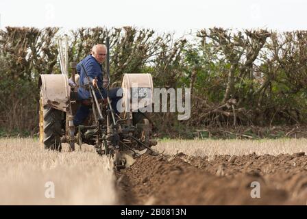 Der alte Bauer kontrolliert seine Furche, nachdem er das Feld in Dunsden Oxfordshire England gepflügt hat Stockfoto