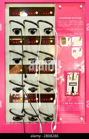 Einfache, bunte Pay-Handy Ladestation in einem Touristenreisegebiet, mit hängenden Kabeln, die von Reisenden verwendet werden, die auf den Philippinen, Asien, zu sehen sind Stockfoto