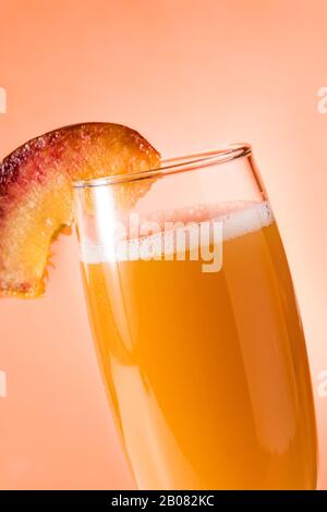 Sektecocktail Bellini auf orangefarbenem Hintergrund Stockfoto