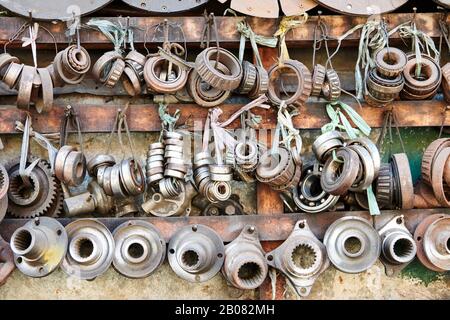 Nahaufnahme einer Reihe von gebrauchten rostigen alten Lagern und anderen Autoteilen, die in einem Auto-Junk-Shop in Iloilo City, Philippinen, Asien in Reihe hängen Stockfoto