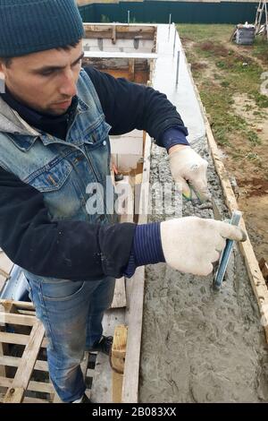 Arbeiter machen Beton in Schalung mit Trowel, Bau eines neuen Hauses.2020 Stockfoto