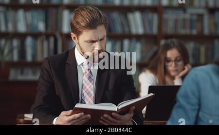 Geschäftsmann Lesebuch in Bibliothek Stockfoto