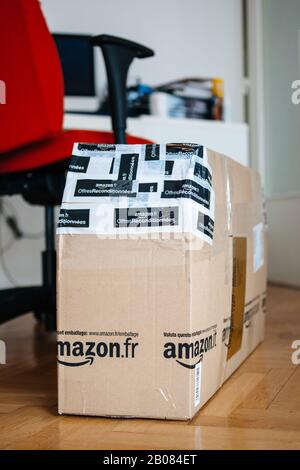 London, Großbritannien - 28. Februar 2014: Neues Paket auf Holzparkett von Amazon France Parcel Warehouse Deals - offre Reconditionnees, verpackt in mehrere Skotchbänder Stockfoto