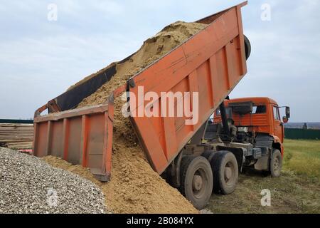 Ein Müllkipper entlädt Sand auf einer Baustelle. Stockfoto