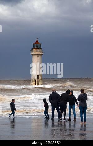 Die Menschen versammeln sich an der Küste, um Storm Ciara im Fort Perch Rock Lighthouse in New Brighton Wallasey UK zu sehen und zu fotografieren Stockfoto