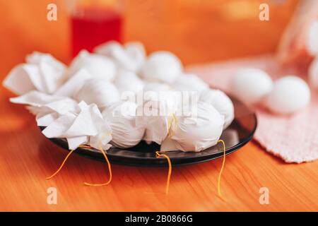 Zur Vorbereitung auf Ostern Malt Und färbt Frau Eier mit Hilfe von Servietten. Bürstenfarbe aus Brille. Frohe ostern. Stockfoto