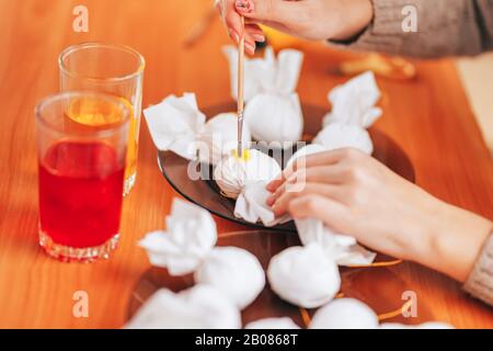 Zur Vorbereitung auf Ostern Malt Und färbt Frau Eier mit Hilfe von Servietten. Bürstenfarbe aus Brille. Frohe ostern. Stockfoto