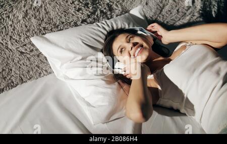 Mädchen hört Musik im Bett Stockfoto