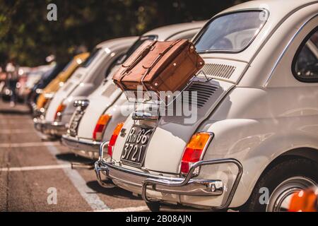 Linie der Fiat-Jahrgänge 500, die an einem sonnigen Tag auf einer Straße in Rom, Italien, geparkt wurden Stockfoto