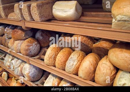 Regale mit Brotlaiben, die in der Bäckerei zu sehen sind Stockfoto