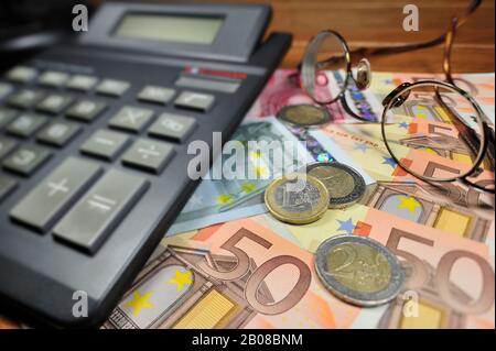 Euro-Banknoten und -Münzen sowie Taschenrechner Stockfoto