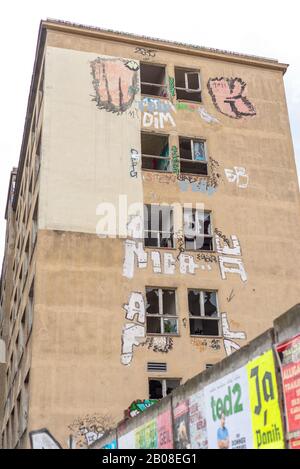 Berlin, Friedrichshain. Referenzen zu YAAM, Young African Art Market mit Wand in bunter Straßenkunst Stockfoto