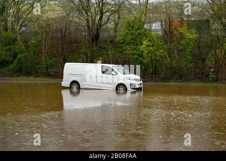 TREFOREST INDUSTRIEGEBIET, IN DER NÄHE VON CARDIFF, WALES - FEBRUAR 2020: Van klemmt in einem überfluteten Parkplatz auf dem Treforest Industrial Estate nahe Cardiff Stockfoto