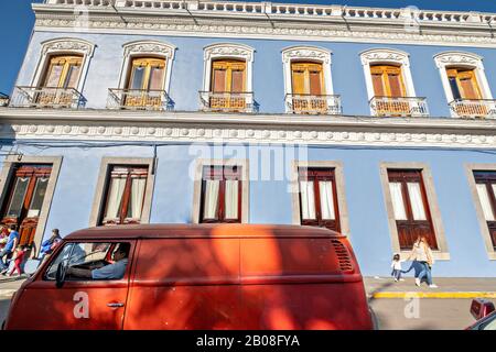 Ein roter Volkswagen-Bus, der vor dem Rathaus im Kolonialstil im zentralen historischen Bezirk Coatepec, Veracruz State, Mexiko, geparkt wurde. Stockfoto