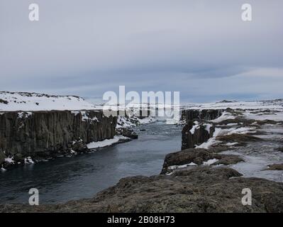 Der große Wasserfall Dettifoss in Island mit schneebedeckter Landschaft Stockfoto