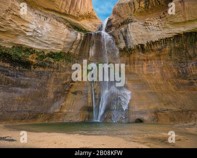 Eine glatte und mosige Felswand mit Wasserfall in einer Schlucht Stockfoto