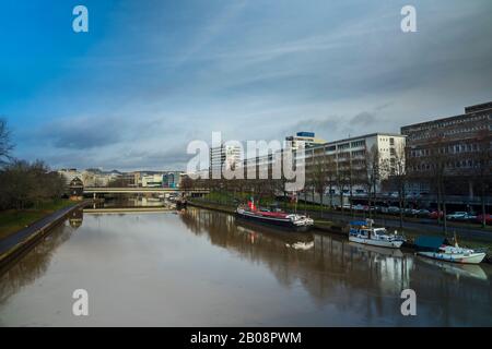 Am Flussufer neben Wolkenkratzern der saarbrücker Stadt verankern Alte Boote und Schiffe am 1. Februar 2020 Stockfoto