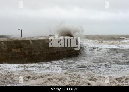 Große Wellen, die während eines großen Sturms über den Cobb in Lyme Regis, Dorset, England, Großbritannien krachen Stockfoto